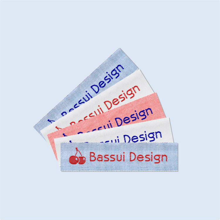 Examples of Bassui Design woven name labels in various colors with custom text in Papyrus font.